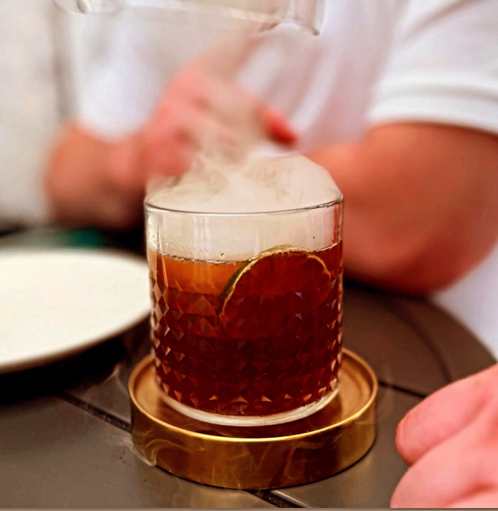 Smoked old fashioned cocktail with dramatic vapour effect